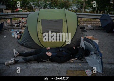 Hong Kong, Cina. Xv Nov, 2019. Un manifestante dormire vicino a una tenda durante la dimostrazione.Dopo una settimana di scioperi e scontri con la polizia e manifestanti occupano ancora il campus dell Università Cinese di Hong Kong in un giorno di calma relativa a. Alla fine della giornata, i manifestanti di nuovo bloccato Tolo autostrada in flash mob azioni e quindi evacuato il campus aiutato da autisti privati dopo l'impostazione dell'ingresso del ponte numero 2 sul fuoco. N. di arresti sono stati eseguiti. Credito: Ivan Abreu/SOPA Immagini/ZUMA filo/Alamy Live News Foto Stock