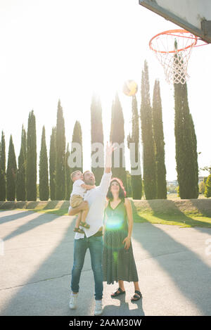 I genitori con figlio giocando netball in posizione di parcheggio Foto Stock