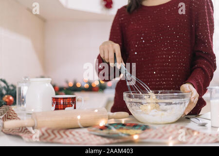 Donna sbattere i cookie impasto nella ciotola di vetro Foto Stock