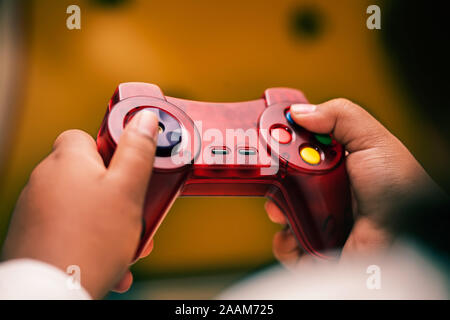 Un po' di mani di bambini che interagiscono e utilizzando un game pad per riprodurre scary video giochi. Foto Stock