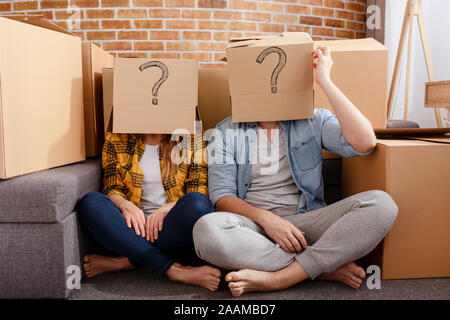 Confuso paio di dover spostare e organizzare tutti i pacchetti. Concetto di successo, illusione, modificare , futuro, confusione, questione. Foto Stock