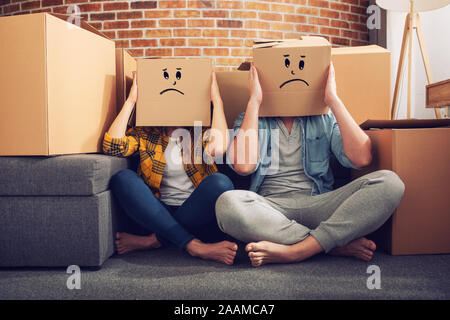 Confuso paio di dover spostare e organizzare tutti i pacchetti. Concetto di successo, illusione, cambiamento e futuro Foto Stock