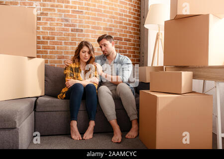 Confuso paio di dover spostare e organizzare tutti i pacchetti. Concetto di successo, illusione, cambiamento e futuro Foto Stock