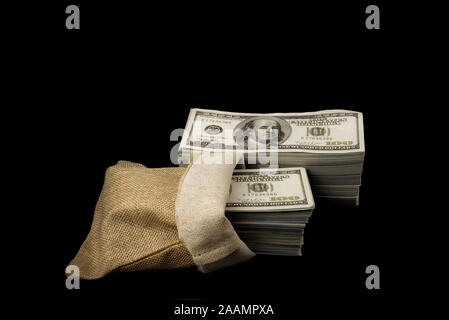 Il sacco di soldi 100 USD dollari banconote di un sacco di soldi a sfondo nero Foto Stock