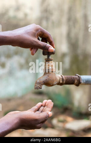 Crisi idrica è una grave minaccia in India e in tutto il mondo,un uomo tenendo la sua mano sotto il rubinetto per acqua Foto Stock