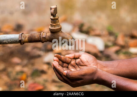 Crisi idrica è una grave minaccia in India e in tutto il mondo,un uomo tenendo la sua mano sotto il rubinetto per acqua. Foto Stock