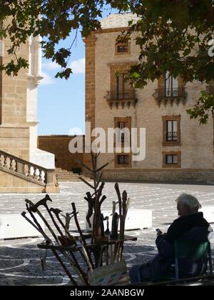 Un uomo Vendita di bastoni da passeggio sotto un albero Foto Stock