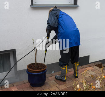 La donna pulisce in lastre di pietra con un lavaggio a pressione Foto Stock