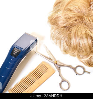 Attrezzo di taglio di capelli e capelli su sfondo bianco Foto Stock