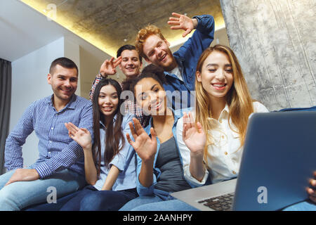 Gruppo di amici aventi parti in ambienti chiusi insieme divertimento video chiamata Foto Stock