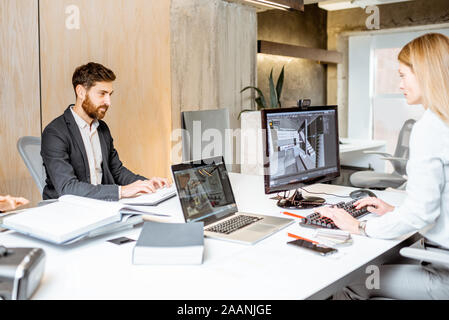 Ufficio creativo dipendenti rendendo interior design sul computer, seduto presso il moderno ufficio di studio di architettura. Concetto di modellazione 3d digitale e progettazione di interni Foto Stock