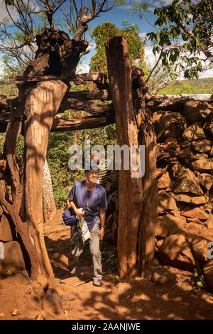 Etiopia, Karat-Konso, Gamole borgo murato, senior turista femminile passando attraverso la porta in pietra costruito la parete Foto Stock