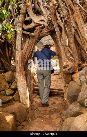 Etiopia, Karat-Konso, Gamole borgo murato, senior turista femminile passando attraverso la porta in pietra costruito la parete Foto Stock