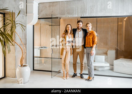 Ritratto di un giovane colleghi insieme permanente nel corridoio della moderna agenzia di marketing o di design studio Foto Stock