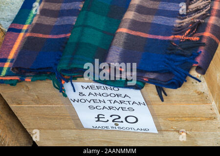 Merino angora & tessuti tartan Sciarpe fatte in Scozia per la vendita sul mercato in stallo a Winchester Mercatino di Natale, Winchester, Hampshire, Regno Unito nel mese di dicembre Foto Stock