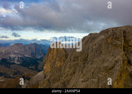 Vista aerea del Brunecker Turm, Sassolungo montagna e passo passo Gardena durante il tramonto. Dolomiti in Alto Adige Foto Stock