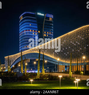 Tashkent, Uzbekistan - 30 Ottobre, 2019: sala congressi e hotel Hilton con colorati illuminazione notturna della città di Tashkent Park Foto Stock