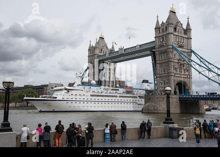 Londra, Regno Unito. 1 Giugno 2015. FTI Berlino, una classica nave da crociera per 412 passeggeri, è trainato da un rimorchiatore sotto il Tower Bridge a valle. Foto Stock