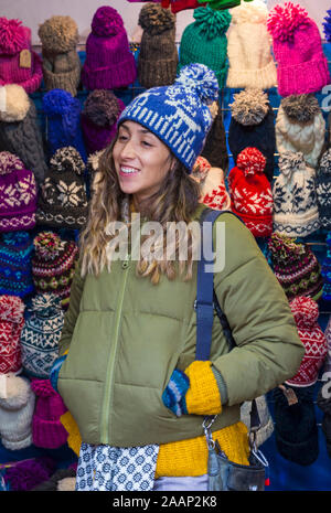 Mercato titolare di stallo vendita di cappelli a Winchester Mercatino di Natale, Hampshire, Regno Unito nel mese di dicembre Foto Stock