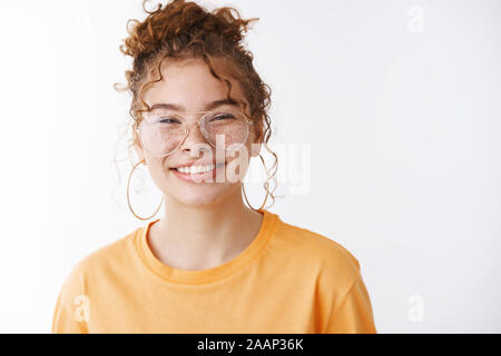 Close-up lucky gioiosa amichevole-cercando femmina programmatore it redhead freckled guance sorridente felicemente lo sguardo di assertivi fotocamera, soddisfatto permanente Foto Stock