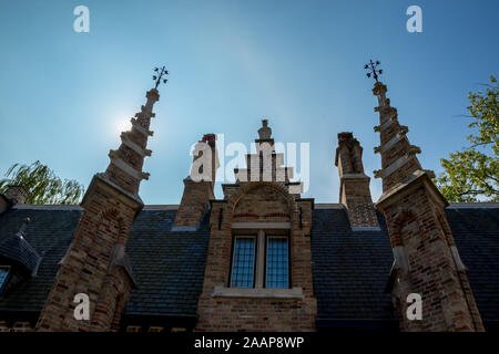 Facciata con torri e Sun dietro, street view del bellissimo centro storico di architettura di Bruges o Brugge, Fiandra occidentale provincia, Belgio. Lo Foto Stock