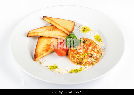 Carni bovine la tartare di manzo con crostini. materie di manzo con cipolle sulla piastra bianca decorata con pomodoro ciliegino. vista superiore Foto Stock