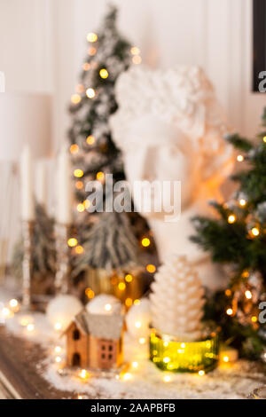 Immagine sfocata del gesso statua di testa circondata da decorazioni di Natale. Foto Stock