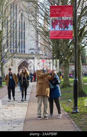 La Cattedrale di Winchester Tis la stagione di skate - giovane tenendo selfie fuori la Cattedrale di Winchester a Winchester, Hampshire, Regno Unito nel mese di dicembre Foto Stock