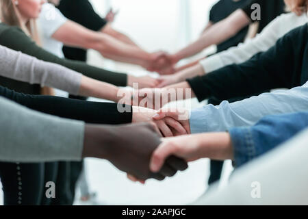 Close up. vari giovani stringono le mani gli uni con gli altri. Foto Stock