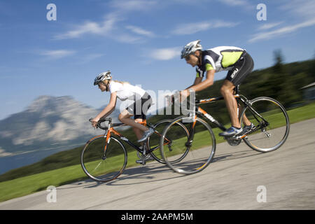 Mann und Frau mit dem Rennrad in alpiner Landschaft Foto Stock