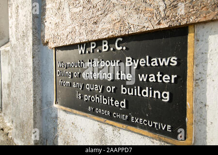 Un segno che indica che byelaws vietare le immersioni o immettendo l'acqua dalle banchine o edifici su Weymouth Harbour. Il Dorset England Regno Unito GB Foto Stock