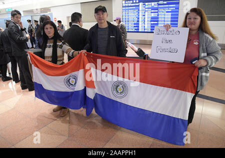 Tokyo, Giappone. Tokyo, Giappone. 23 Nov, 2019. Le persone in possesso di una bandiera del Paraguay all'uscita degli arrivi dopo l arrivo del Papa Francesco a Haneda Aeroporto Internazionale di Tokyo Giappone le persone non erano in grado di vedere il Papa e sono andato a casa dopo aver appreso che il papa ha lasciato attraverso una diversa uscita. Alcune delle persone in attesa che il Papa ha guidato ore a testimonianza del suo arrivo e avere uno scorcio del papa ma non sono stati in grado di vedere lui. Foto scattata Sabato 23 Novembre, 2019. Foto di: Ramiro Agustin Vargas Tabares Credito: Ramiro Agustin Vargas Tabares/ZUMA filo/Alamy Live News Foto Stock