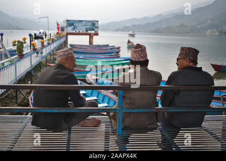 Locale uomini nepalese in chat in riva al lago Foto Stock