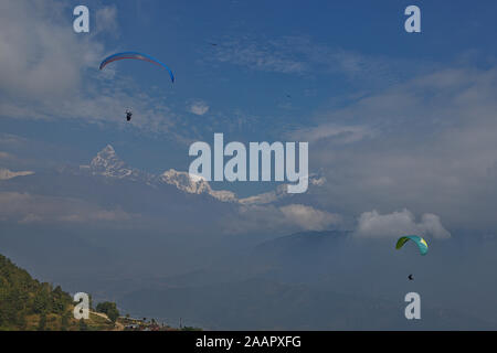 Parapendio oltre a Pokhara con una vista della catena Hannapurna Foto Stock
