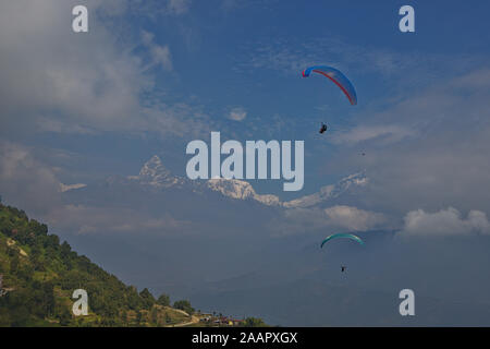 Parapendio oltre a Pokhara con una vista della catena Hannapurna Foto Stock