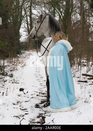 Una magica cercando girl e cavallo in un paesaggio innevato. Foto Stock