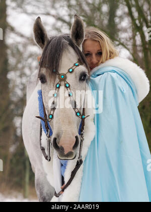Una magica cercando girl e cavallo in un paesaggio innevato. Foto Stock