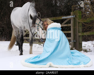Una magica cercando girl e cavallo in un paesaggio innevato. Foto Stock