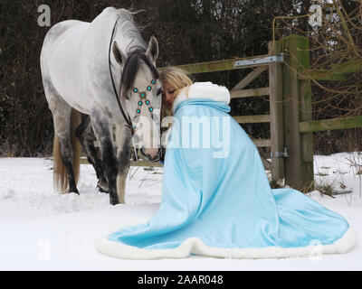 Una magica cercando girl e cavallo in un paesaggio innevato. Foto Stock