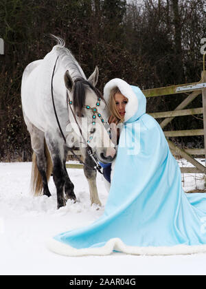 Una magica cercando girl e cavallo in un paesaggio innevato. Foto Stock