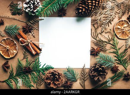 Naturale Natale decorazioni fatte di legno e pigne nelle quali senza materia plastica. Doni. Vuoto bianco del foglio di carta. Rifiuti Zero Natale, concetto laici piana. Foto Stock