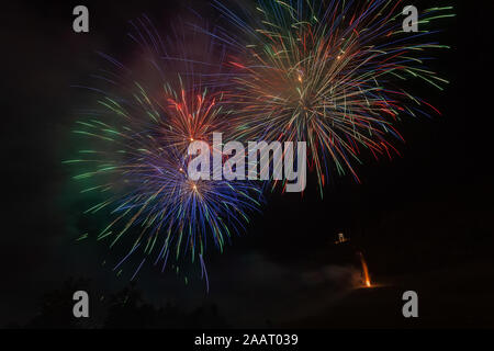 Awesome colorato esplosioni di fuochi d'artificio su alberi silhouette Foto Stock