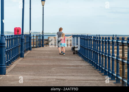 Ragazza giovane e madre del cane a piedi lungo un molo di inglese Foto Stock