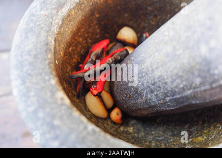 Mortaio di pietra con peperoncino per rendere il curry in cibo tailandese strumenti importanti per la fabbricazione di pasta di peperoncino utilizzato per la cottura di cibo tailandese Foto Stock