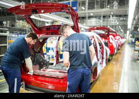 Due colleghi impegnati nella moderna fabbrica di automobili Foto Stock