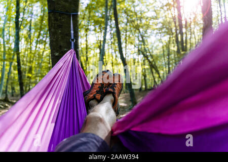 Punto di vista colpo di uomo disteso in amaca in una foresta Foto Stock