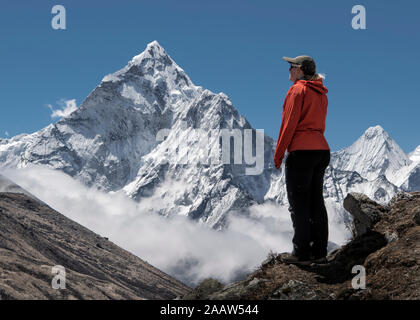 Donna che guarda il triidrato di alluminio sul Nuptse mountain, Himalaya, Solo Khumbu, in Nepal Foto Stock