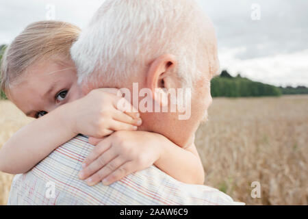 La nipote abbracciando il suo nonno all'aperto Foto Stock