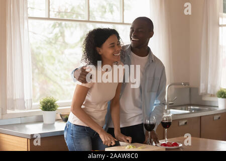 Felice famiglia americana africana per la cottura in cucina insieme Foto Stock