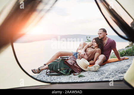 Vista dalla tenda del giovane che giace una vista del lago durante il viaggio escursionistico. avel Lifestyle concetto Vacanze avventura all'aperto Foto Stock